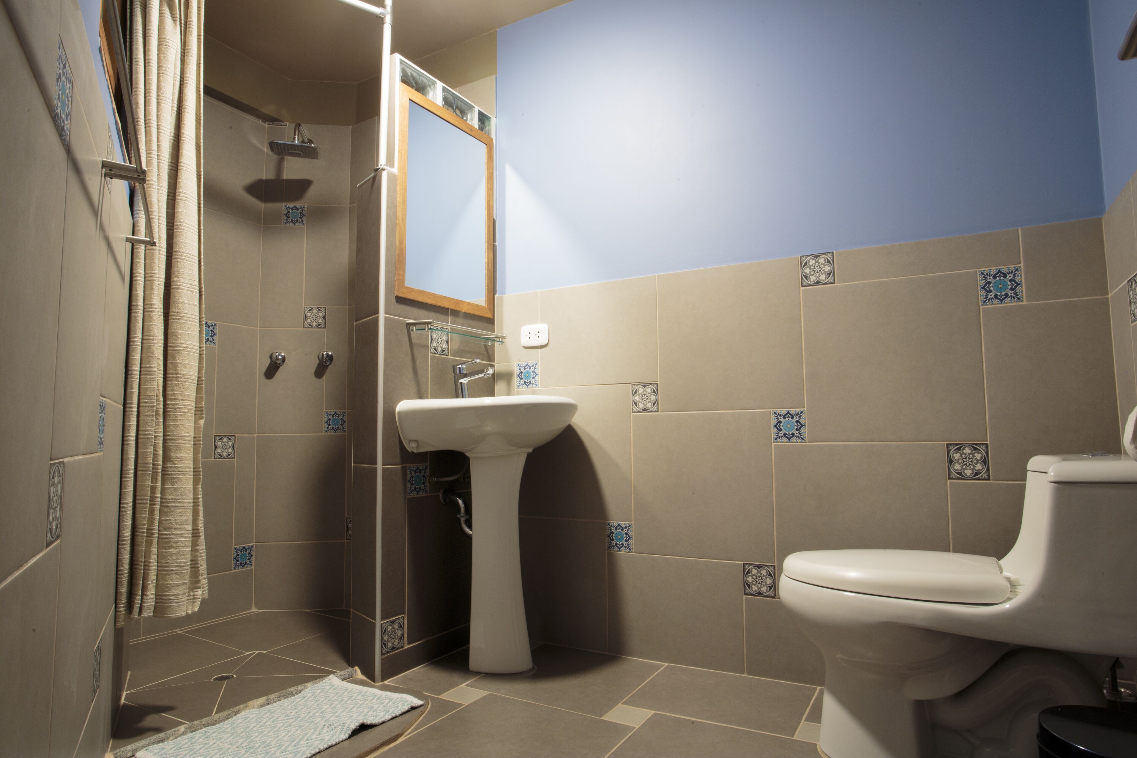 Un baño con ducha, lavamanos e inodoro.