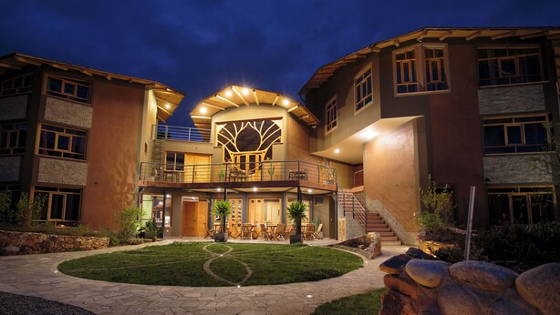 A modern hotel with a central courtyard, outdoor seating, and a staircase leading to an upper level. - Fleur Lodge (Acopampa)