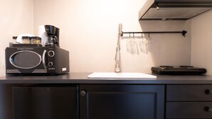 A kitchen with a microwave, coffee maker, and a knife block on the counter. - Cozy Apartment with Terrace | Casco Viejo | M6 (Ciudad de Panamá)
