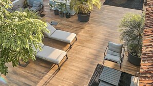 A rooftop patio with outdoor seating, potted plants, and a view of the surrounding area. - Casa Boyd - 2BR Old Town with Access to Pool & 360° Rooftop (Ciudad de Panamá)