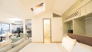 Une chambre d’hôtel comprenant un lit, un coin salon, une kitchenette et une vue sur l’extérieur.