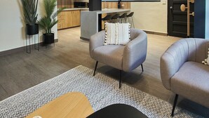 A modern living room with a sofa, a coffee table, and a dining area with a kitchen in the background. - Outstanding double appartment with pool and rooftop (Ciudad de Panamá)