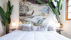 A bed with a white quilted bedspread, fluffy pillows, and a wall mural. - Two Bedrooms w/ Bathroom, Kitchen, Pool & Rooftop  A11 (Ciudad de Panamá)