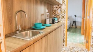 A kitchen with wooden cabinets, a stainless steel sink, and a countertop with a blender and bowls. - Two Bedrooms w/ Bathroom, Kitchen, Pool & Rooftop  A11 (Ciudad de Panamá)