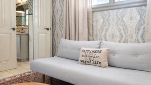 A light grey sofa with a cushion that reads "HAPPINESS is not a destination it is a way of life."