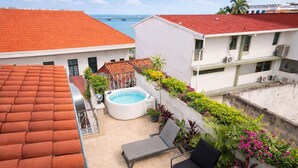 Una azotea con piscina, sillas de descanso y vistas al mar.