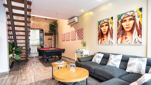 Ein modernes Wohnzimmer mit Billardtisch, einer Couch und einem Couchtisch.