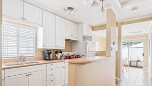 A kitchen with white cabinets, a countertop, and a built-in island.