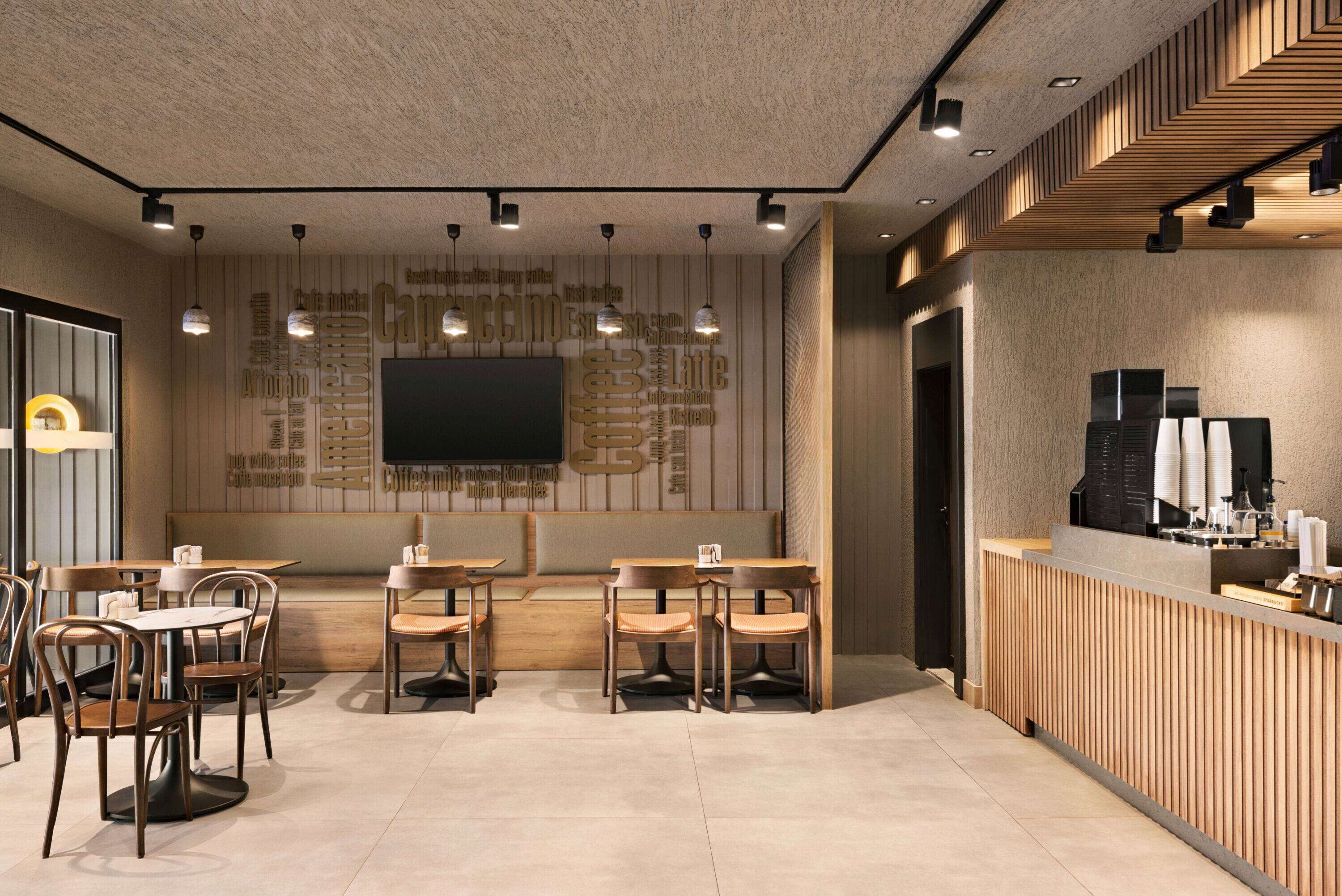 A modern coffee shop interior with a wooden reception desk, seating area with tables and chairs, and a large screen on the wall.