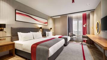 A modern hotel room with two beds, a desk, a chair, and a TV.