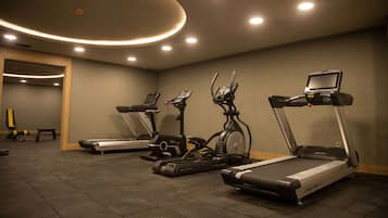 A gym with treadmills, stationary bikes, and a rowing machine.
