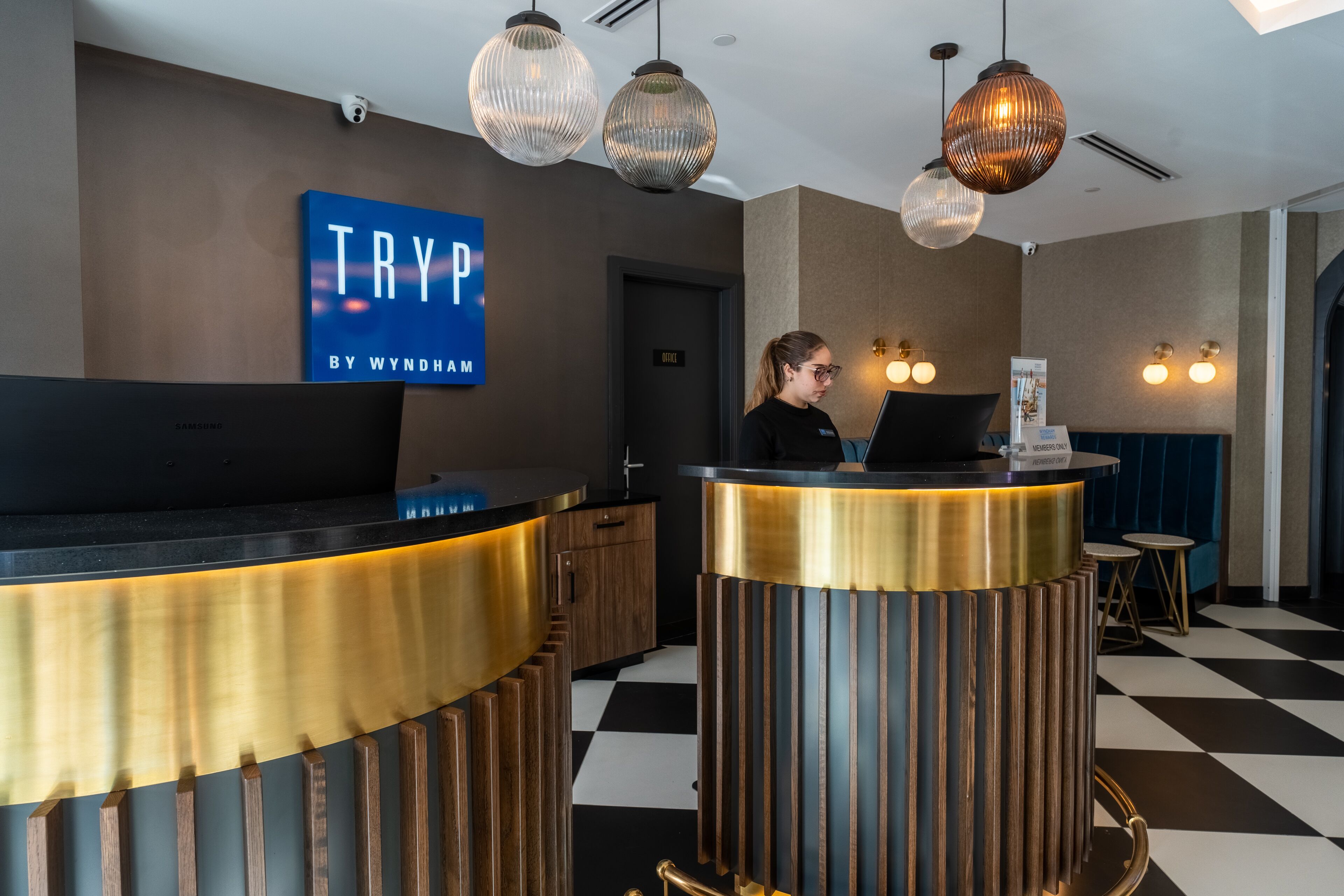 A reception desk with a 'TRY' sign, a laptop, and a check-in counter.