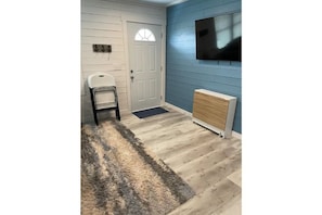 Cozy room with a comfortable chair, a small rug, and a radiator.