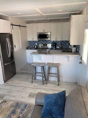 Compact kitchen with modern appliances, white cabinetry, and a small island for a functional workspace.