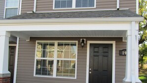 A two-story house with a front porch, a black front door, and a number '19' on the right side. - Cheerful 2-Bedroom Townhouse with Pool (Clarksville)