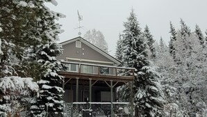 Ein zweistöckiges Haus mit überdachter Veranda und Satellitenschüssel.