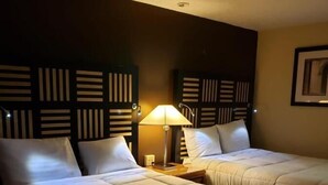 A hotel room with two beds, a nightstand with a lamp, and a wall-mounted light fixture. - Hotel M Morgantown - WVU Area (Morgantown)