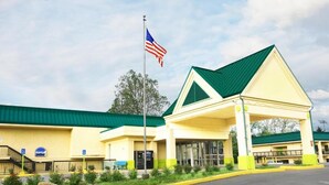 A hotel with a green roof, a flagpole with an American flag, and a covered entrance area. - Hotel M Morgantown - WVU Area (Morgantown)