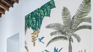 A staircase with a tropical mural, a vintage bicycle, and a small monkey figurine.