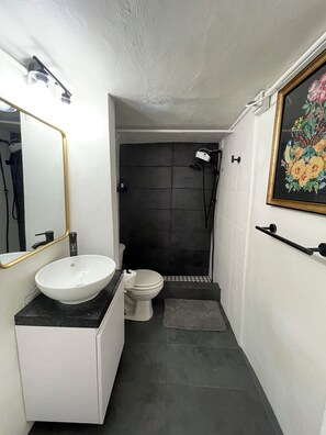Een douche, handdoeken, zeep, toiletpapier