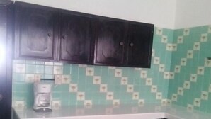 A kitchen with dark cabinets, a white countertop, and patterned green and white tiles. - Hotel D lina Princess suites (San Cristóbal de las Casas)