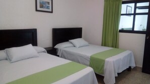 Two single beds with white and green bedspreads, a dark headboard, a green curtain, and a window with a view. - Hotel D lina Princess suites (San Cristóbal de las Casas)