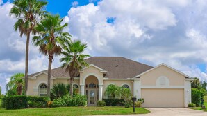 A single-story house with a beige facade, a brown roof, and a front garage. - Stunning Renovated Villa Overlooking Golf Course (Davenport)