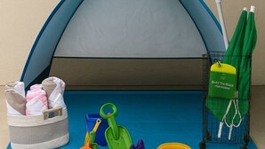 A tent with a blue canopy, a green bag, and various beach toys. - Stunning Renovated Villa Overlooking Golf Course (Davenport)
