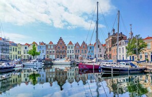 A canal with boats docked, reflecting the buildings. - Awesome home in Heinkenszand with WiFi (Heinkenszand)