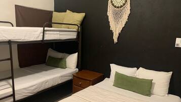 Dormitorio con literas, una mesita de noche y un adorno en la pared.