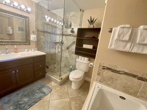 Une salle de bain moderne avec une douche à parois de verre, une baignoire, un meuble-lavabo avec un miroir et des toilettes.