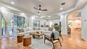 Ein geräumiges Wohnzimmer mit einer großen Eckcouch, einem Couchtisch und einem Essbereich mit einem Holztisch und Stühlen.