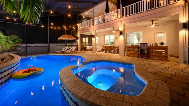 Ein Swimmingpool mit Whirlpool, Liegestühlen und einer Essgegend mit Gartenmöbeln.
