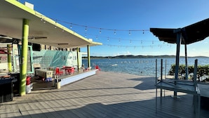 A wooden deck with outdoor seating, a covered area, and a view of the water. - Walking distance to Boqueron, private pool, full A/C, sleeps 10 (Boquerón)