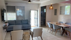 A modern living room with a sofa, dining table, chairs, and a ceiling fan. - Walking distance to Boqueron, private pool, full A/C, sleeps 10 (Boquerón)