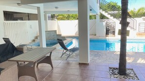 A covered outdoor area with a pool, lounge chairs, and a table. - Walking distance to Boqueron, private pool, full A/C, sleeps 10 (Boquerón)