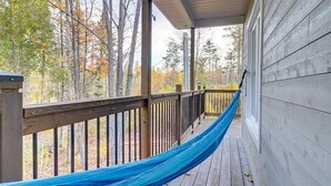 Una terraza de madera con una hamaca azul.