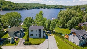 Un barrio residencial con casas, un lago y una colina boscosa.