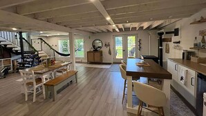 Amplia sala de estar integrada con cocina, comedor y una escalera que conduce a un nivel superior.