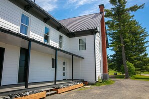 A two-story building with a covered porch and a chimney.