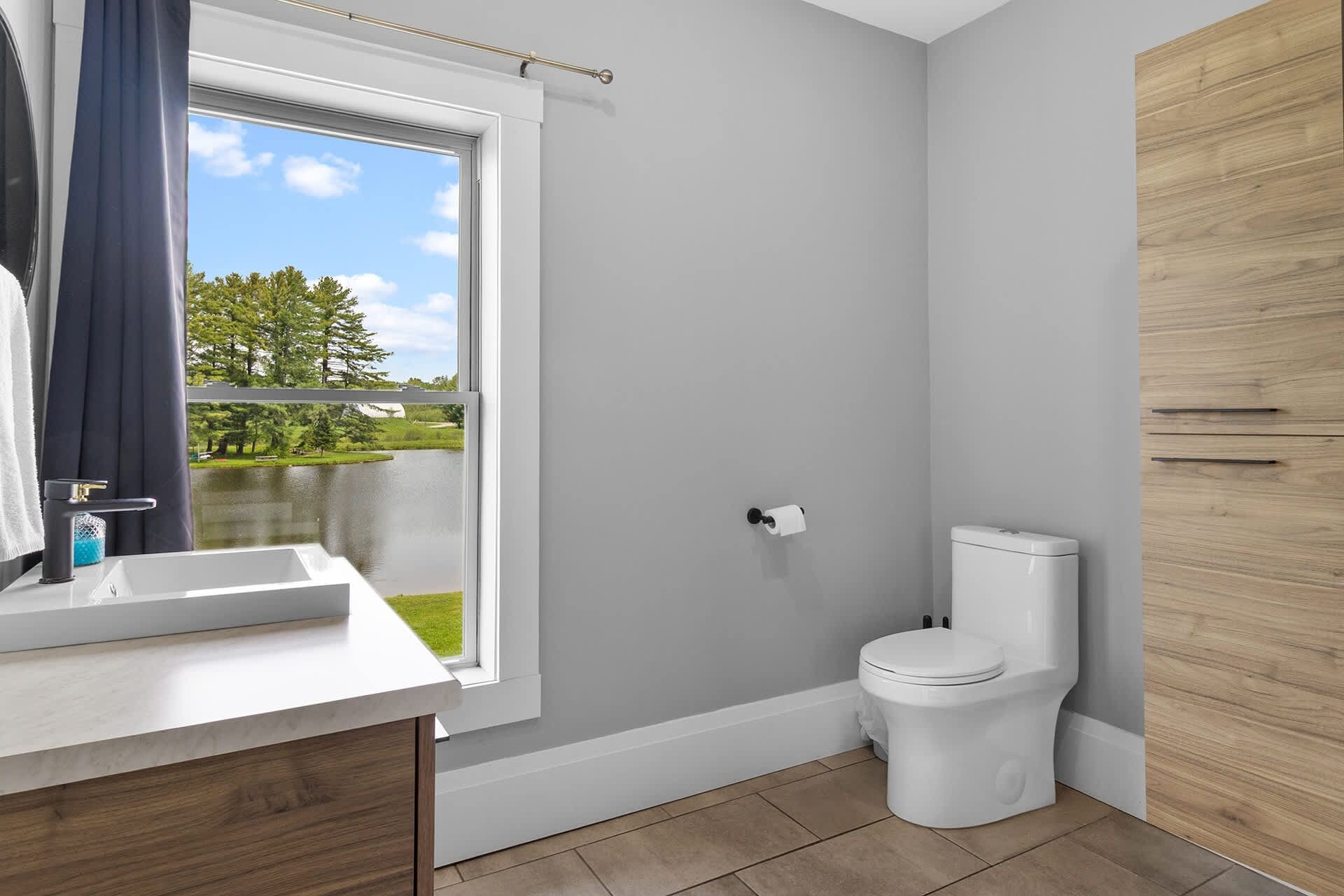 Une salle de bain avec une fenêtre, des toilettes et un lavabo.