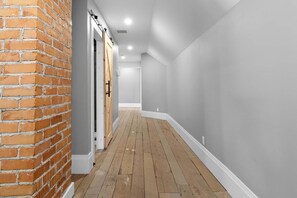 A hallway with a brick wall on one side and a grey wall on the other, leading to a door. - Access to the river - Spa - Inground pool (Cookshire-Eaton)