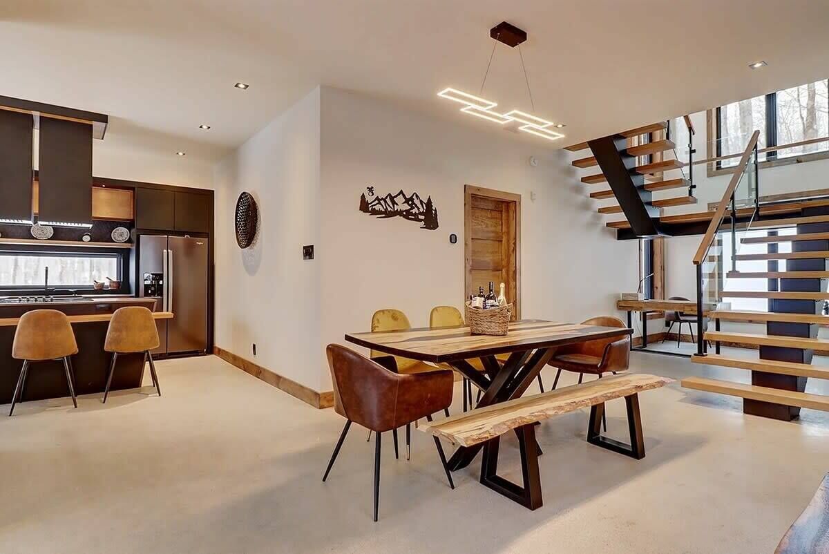 A modern kitchen with a built-in oven and a dining area with a wooden table and chairs.
