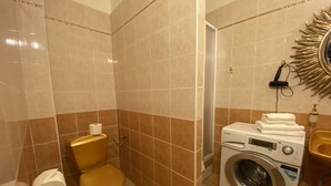 Een badkamer met een toilet, een wasmachine en een wastafel.