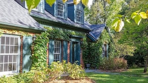 A traditional house with a gabled roof, brick exterior, and green shutters. - Brome Lake - Inground Pool - Spa - Lumen (Knowlton)