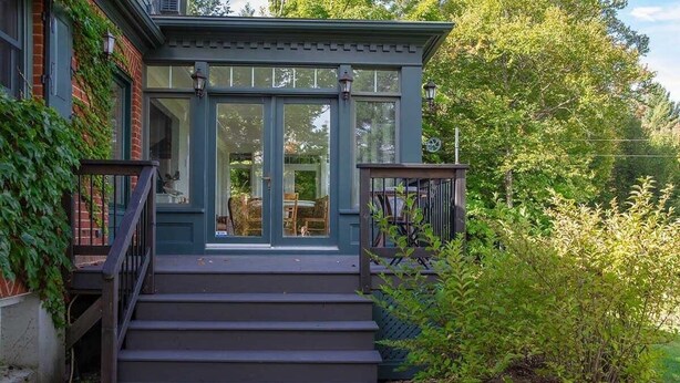 A house with a front porch, steps leading to a door, and a garden area. - Brome Lake - Inground Pool - Spa - Lumen (Knowlton)