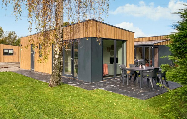 Een modern gebouw met een houten gevel en grote glasramen.