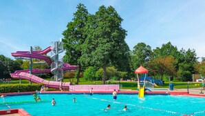 Une piscine avec plusieurs toboggans et un espace aquatique.