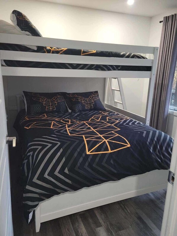 A bunk bed with a geometric-patterned bedspread and matching pillows. - Mount Orford - Spa - Neptune (Orford)