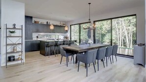 Una cucina moderna con isola centrale, posti a bar e un grande tavolo da pranzo.